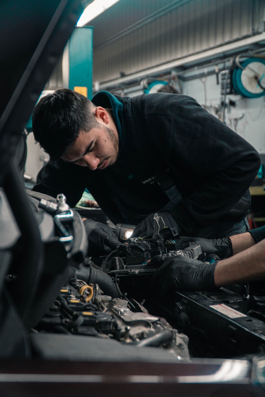 Mechanic diagnosing an engine under the hood in a service bay