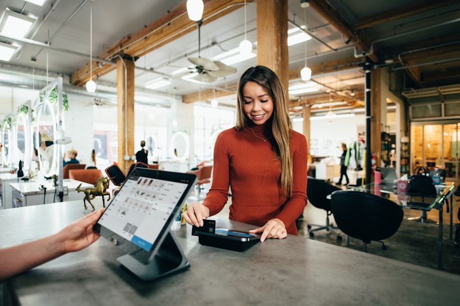 Salon client smiling while paying at the front desk on a tablet point of sale